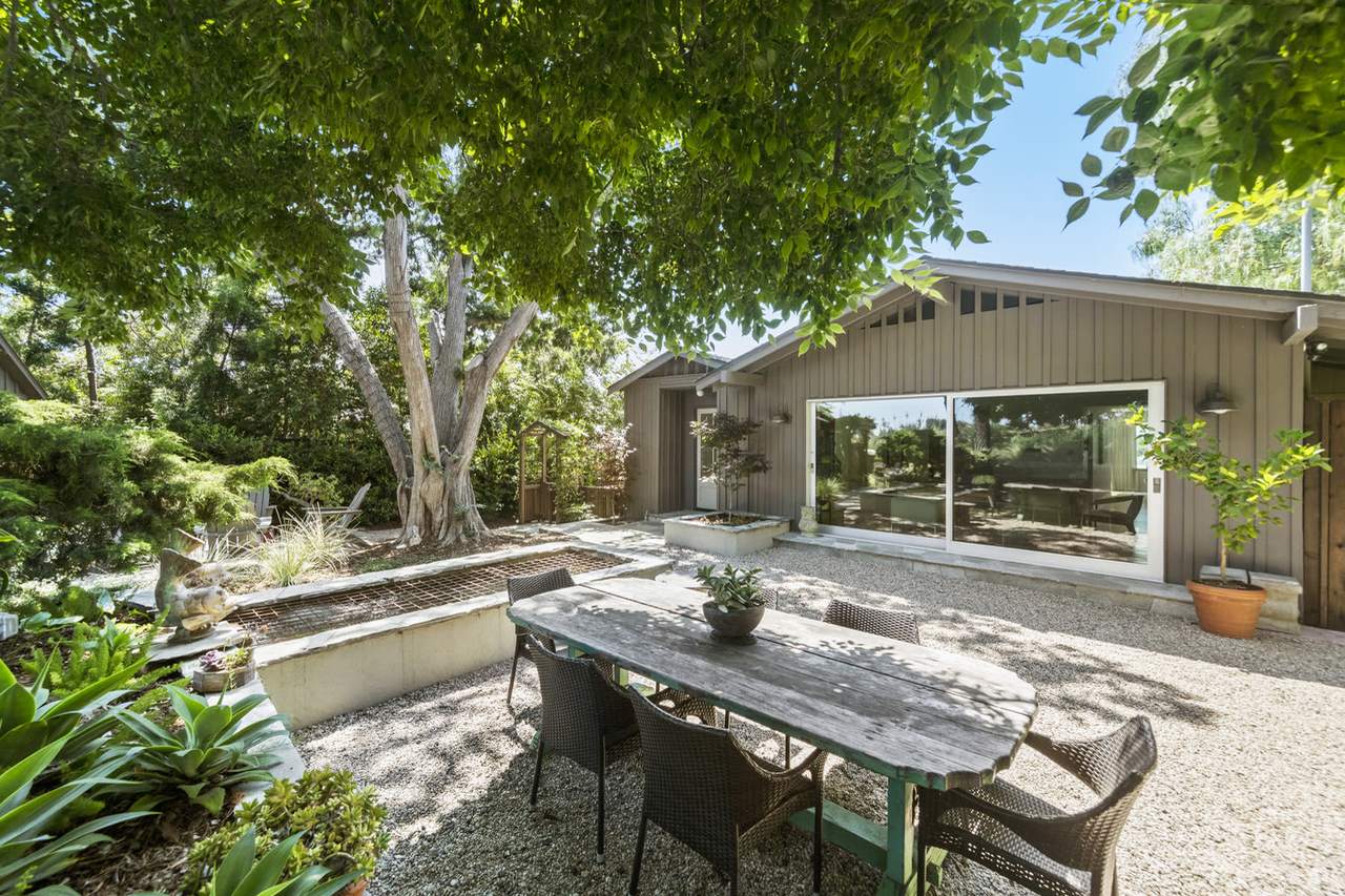 Main house seen from the gravel patio under the trees